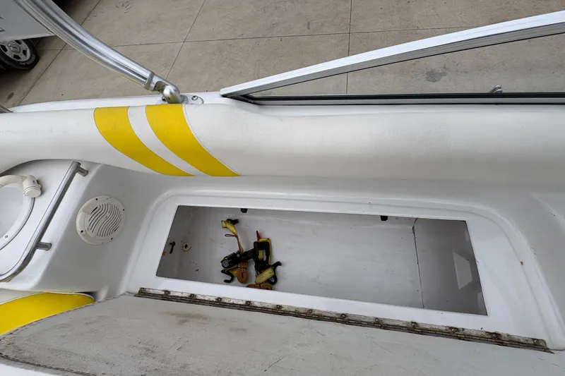 Slide: The Image of 2003 Splendor 240 Platinum boat interior with open storage compartment and yellow accents. - 24