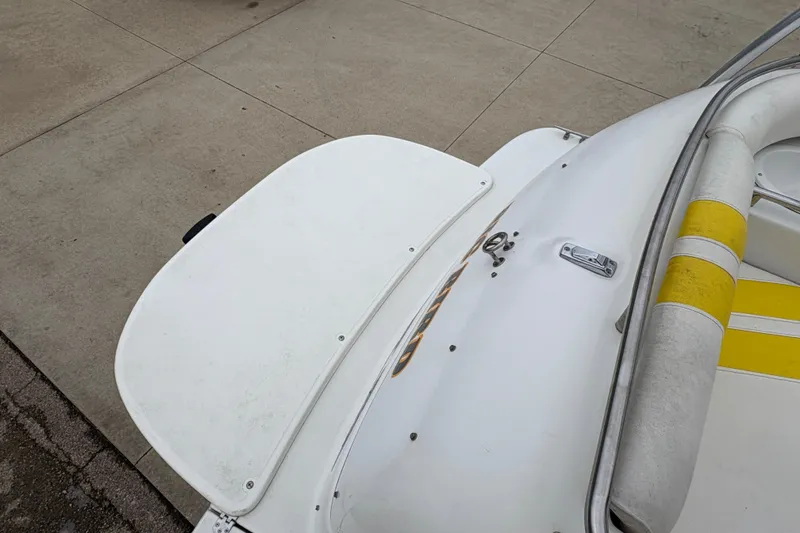 Slide: The Image of 2003 Splendor 240 Platinum boat with white and yellow seating, docked on concrete. - 29