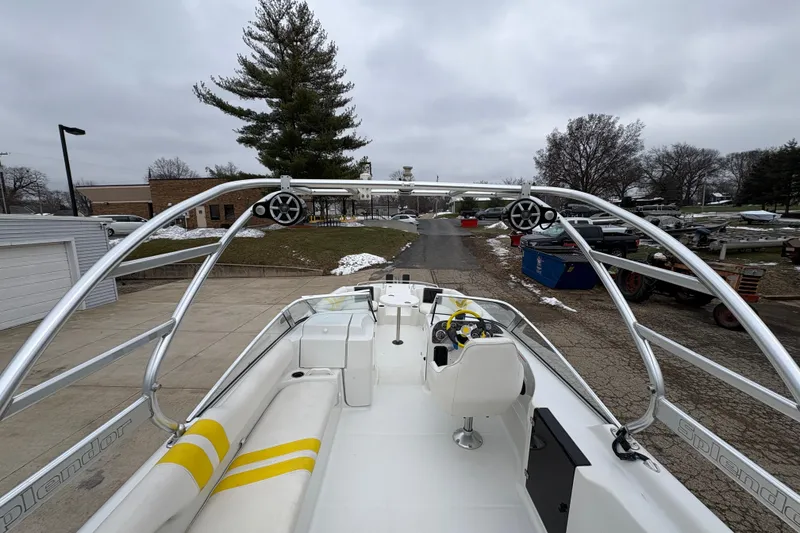 Slide: The Image of 2003 Splendor 240 Platinum boat with sleek design and spacious seating, parked outdoors. - 31