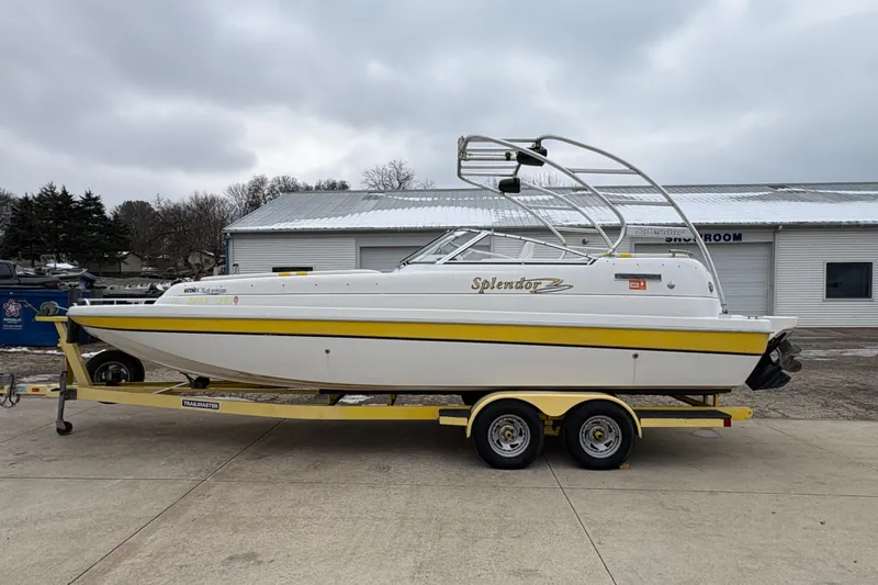 Slide: The Image of 2003 Splendor 240 Platinum boat on trailer, white with yellow accents, parked outdoors. - 5