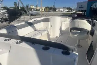 Slide: The Image of 2018 Bayliner 210 Deck Boat with spacious seating and modern design in a marina setting. - 6