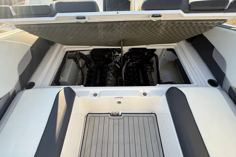 Slide: The Image of 2021 Yamaha Boats 252S engine compartment with dual engines, open hatch, and cushioned seating. - 16