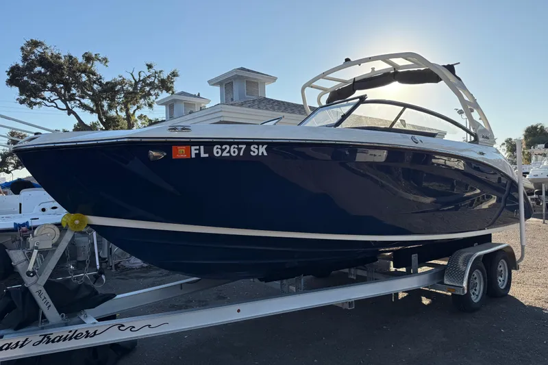 Slide: The Image of 2021 Yamaha Boats 252S on trailer, parked outdoors with trees and buildings in background. - 3
