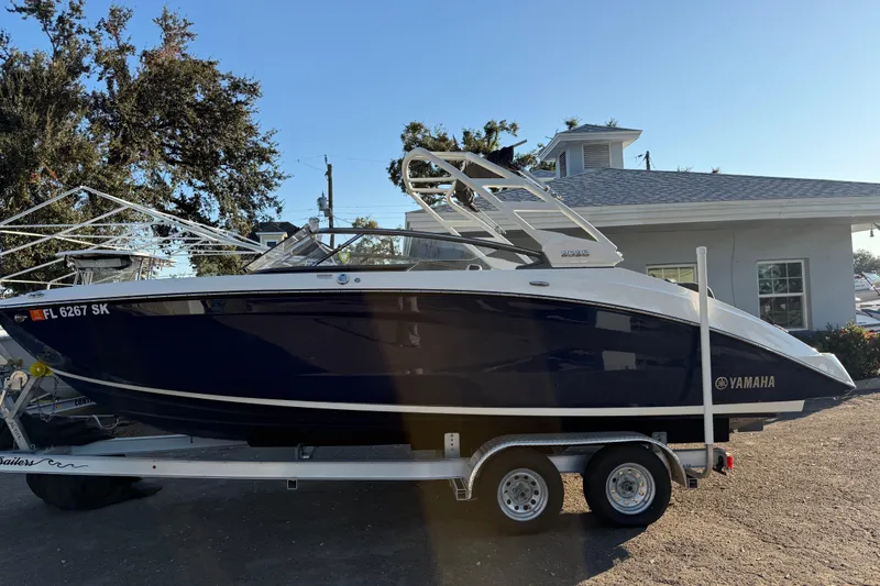 Slide: The Image of 2021 Yamaha Boats 252S on trailer, parked outdoors near a building. - 4