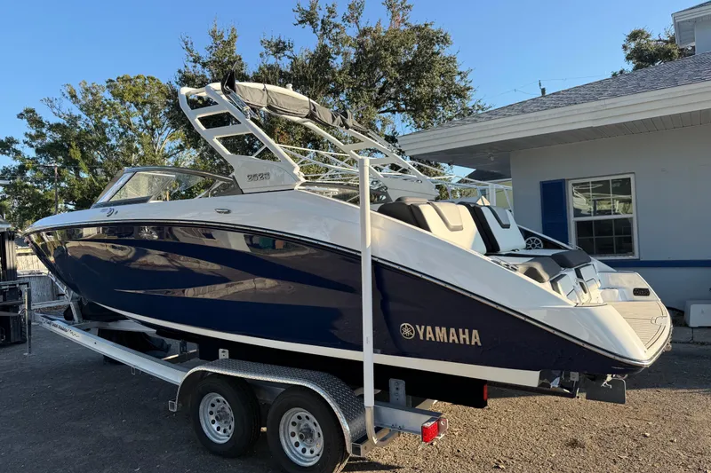 Slide: The Image of 2021 Yamaha Boats 252S on trailer, parked outdoors near a house. - 5