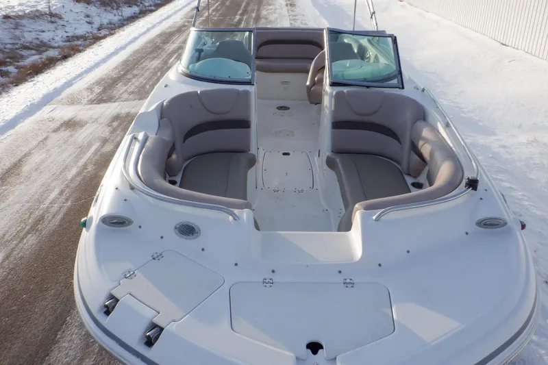 Slide: The Image of 2013 Hurricane SunDeck 2400 IO boat on snowy ground, showcasing spacious seating. - 2