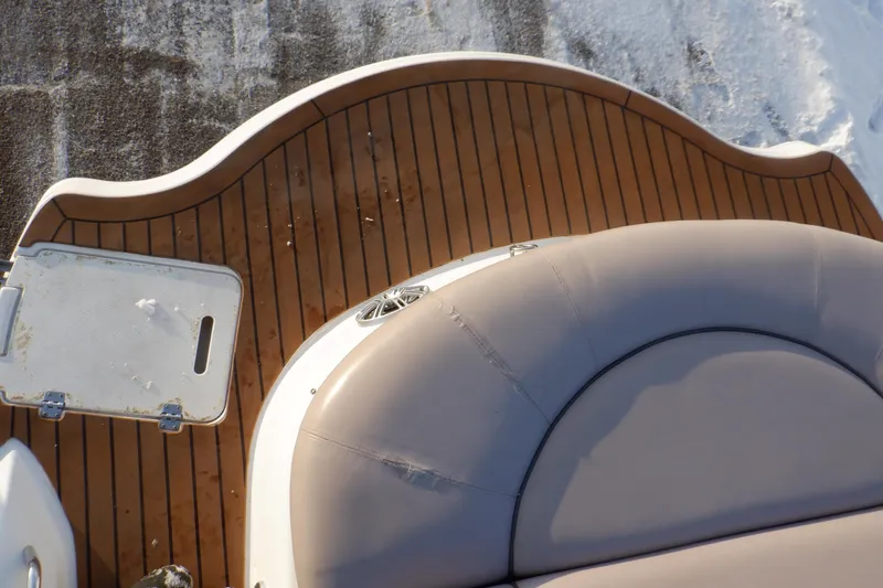 Slide: The Image of 2013 Hurricane SunDeck 2400 IO boat deck with cushioned seating and wooden flooring. - 23