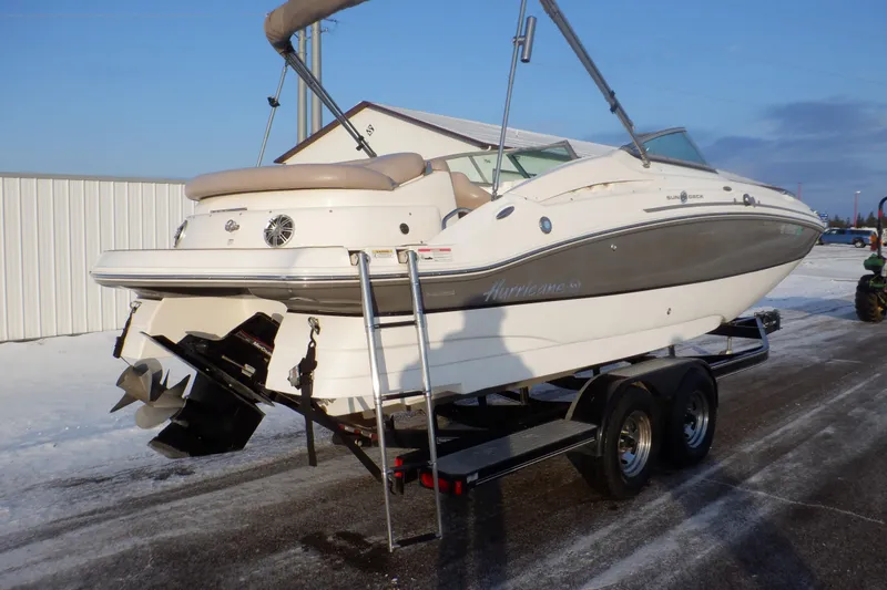 Slide: The Image of 2013 Hurricane SunDeck 2400 IO boat on trailer, parked outdoors in snowy setting. - 3