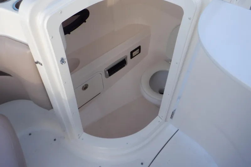 Slide: The Image of 2013 Hurricane SunDeck 2400 IO boat interior with compact toilet and storage. - 34
