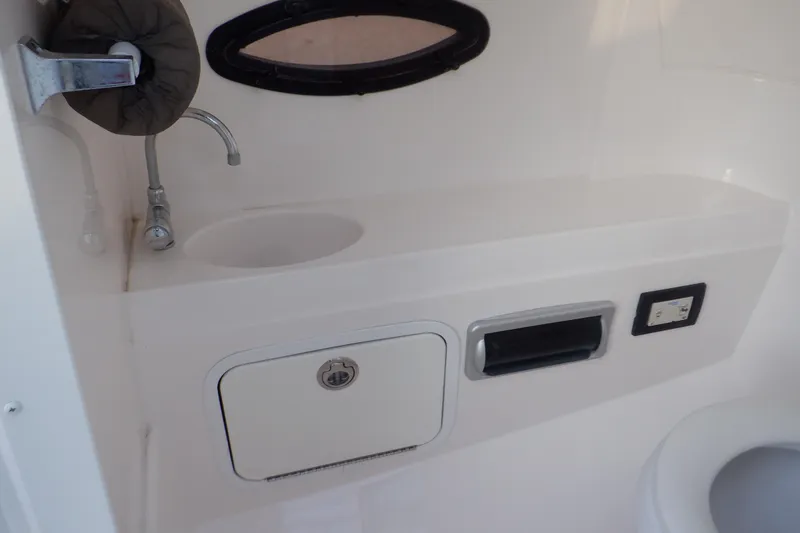 Slide: The Image of 2013 Hurricane SunDeck 2400 IO boat interior with sink and storage compartment. - 35