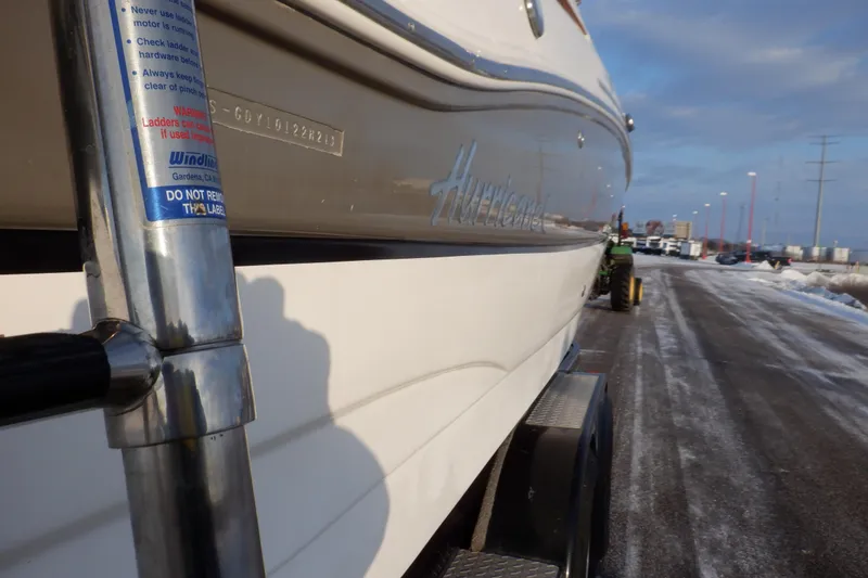 Slide: The Image of 2013 Hurricane SunDeck 2400 IO boat on trailer, parked on snowy road. - 7