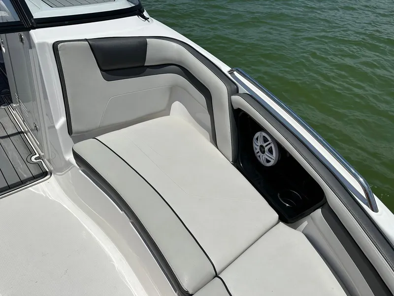 Slide: The Image of 2020 Yamaha AR240 boat interior with cushioned seating and speaker, near water. - 11