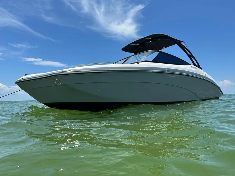 Slide: The Image of 2020 Yamaha AR240 boat on calm green water under a clear blue sky. - 2