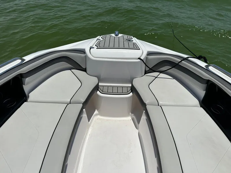 Slide: The Image of 2020 Yamaha AR240 boat interior with cushioned seating on calm water. - 6