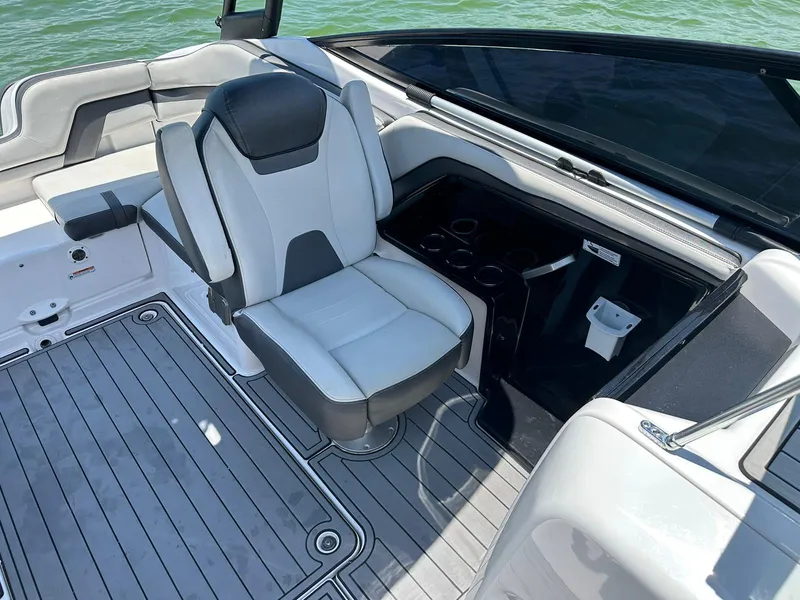 Slide: The Image of 2020 Yamaha AR240 boat interior with seating and cup holders on a sunny day. - 8