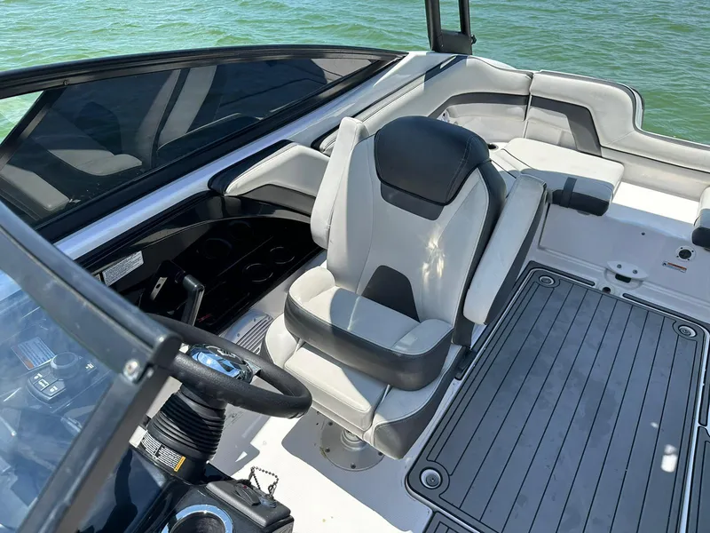 Slide: The Image of 2020 Yamaha AR240 boat interior with steering wheel and seating, on calm water. - 9