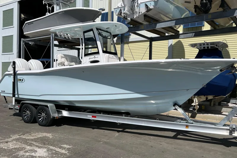 Slide: The Image of 2024 Sea Hunt Gamefish 27 Coffin Box boat on calm water near docks. - 1