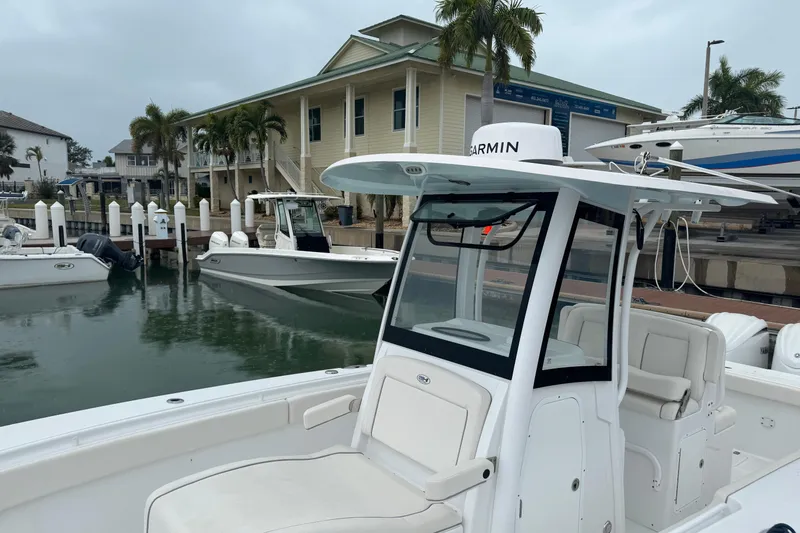 Slide: The Image of 2024 Sea Hunt Gamefish 27 Coffin Box boat docked at marina with palm trees. - 15