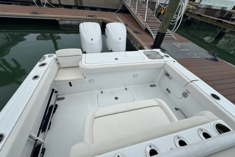 Slide: The Image of 2024 Sea Hunt Gamefish 27 Coffin Box boat interior at dock, featuring dual engines. - 17