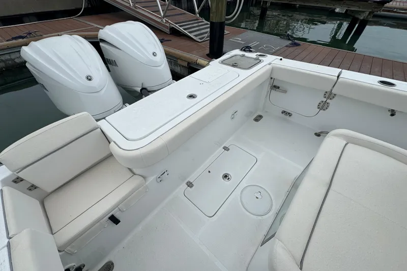Slide: The Image of 2024 Sea Hunt Gamefish 27 Coffin Box boat interior with twin engines at dock. - 18