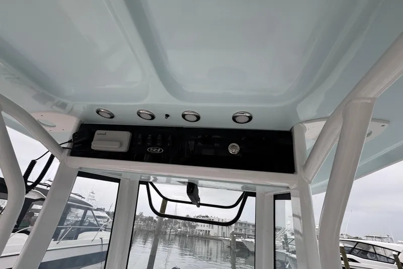 Slide: The Image of 2024 Sea Hunt Gamefish 27 Coffin Box boat interior with control panel and overhead lights. - 20
