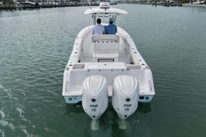 Slide: The Image of 2024 Sea Hunt Gamefish 27 Coffin Box boat with dual 250 V6 engines on calm water. - 4