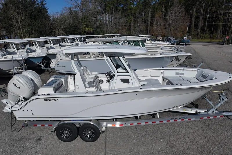 Slide: The Image of 2026 Sea Fox 288 Commander boat on trailer, parked among similar vessels. - 2