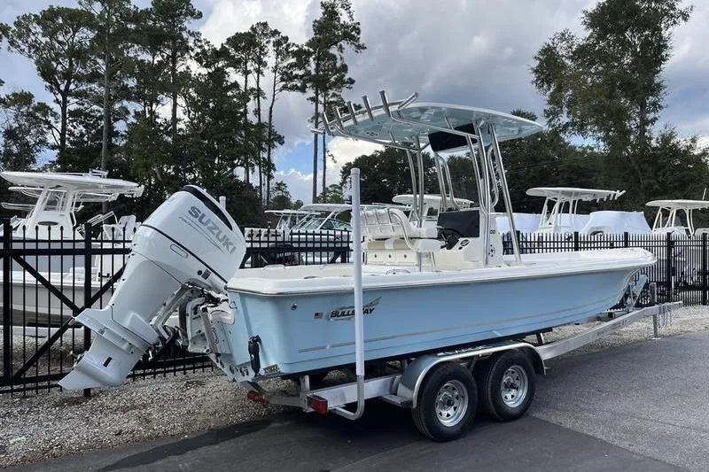 Slide: The Image of 2025 Bulls Bay 2400 boat on trailer with Suzuki outboard motor, parked outdoors. - 3