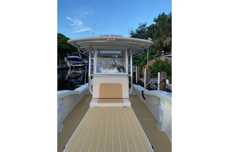 Slide: The Image of 2019 Custom Carolina boat with spacious deck and sleek design, docked by lush greenery. - 11