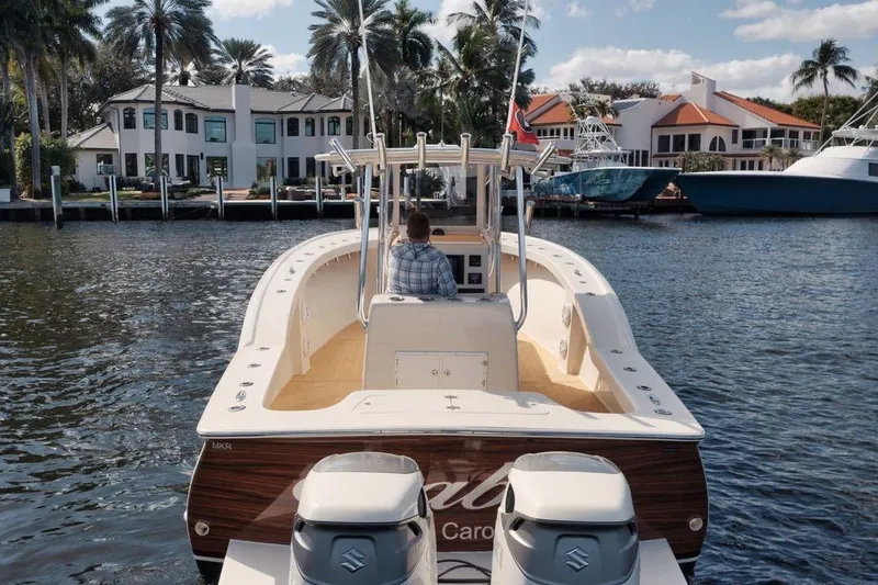 Slide: The Image of 2019 Custom Carolina boat cruising near waterfront homes and palm trees. - 15