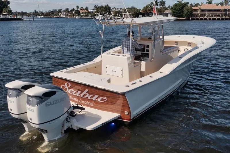 Slide: The Image of 2019 Custom Carolina boat with twin Suzuki engines on a calm waterway. - 5