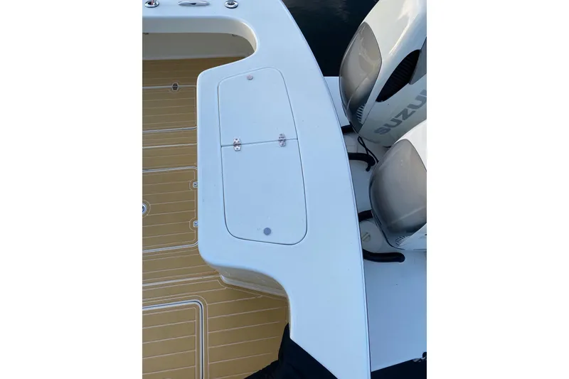 Slide: The Image of 2019 Custom Carolina boat deck with Suzuki engines, featuring a white hatch and tan flooring. - 14