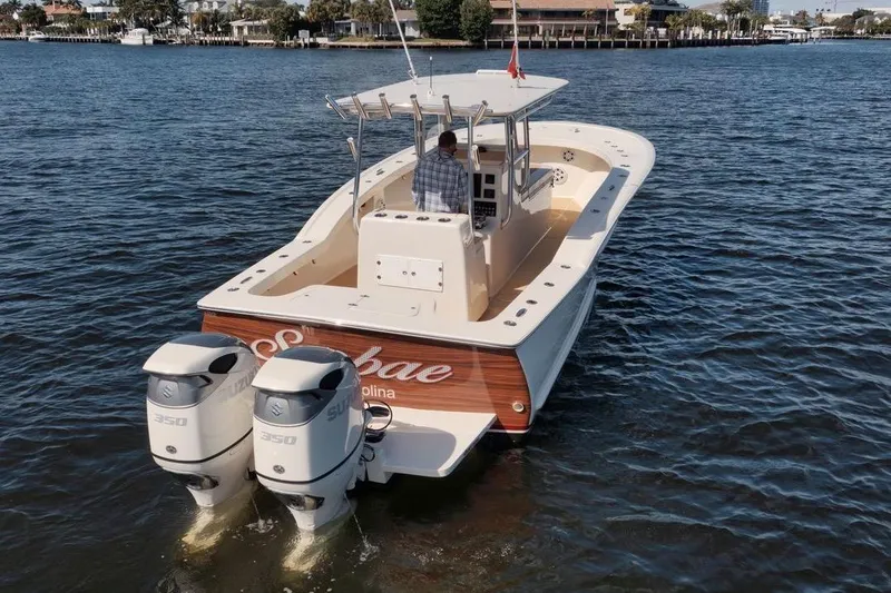 Slide: The Image of 2019 Custom Carolina boat with dual Suzuki 350 engines on a calm waterway. - 6