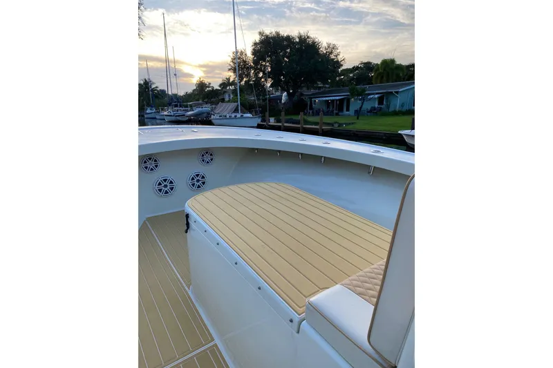 Slide: The Image of 2019 Custom Carolina boat deck with seating, docked at sunset. - 9