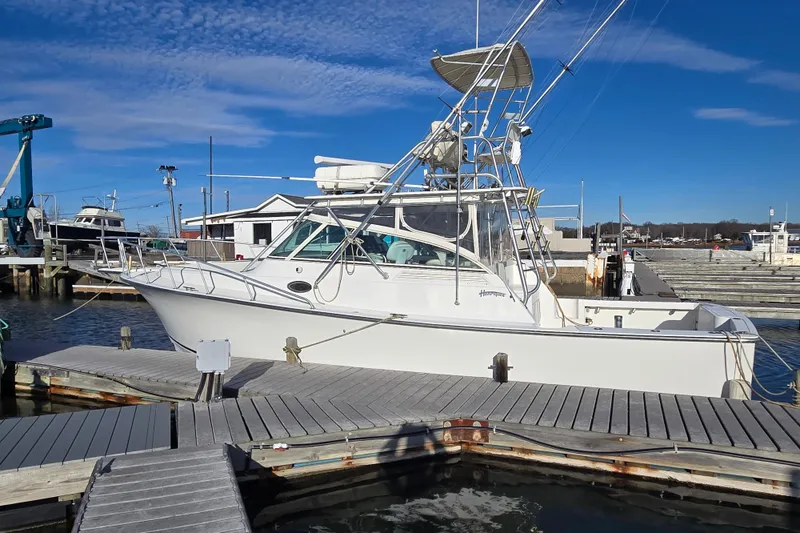 Slide: The Image of 2001 Henriques 35 Flybridge boat docked at marina under clear blue sky. - 2