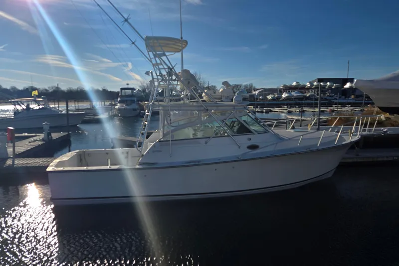 Slide: The Image of 2001 Henriques 35 Flybridge boat docked at marina under clear blue sky. - 5