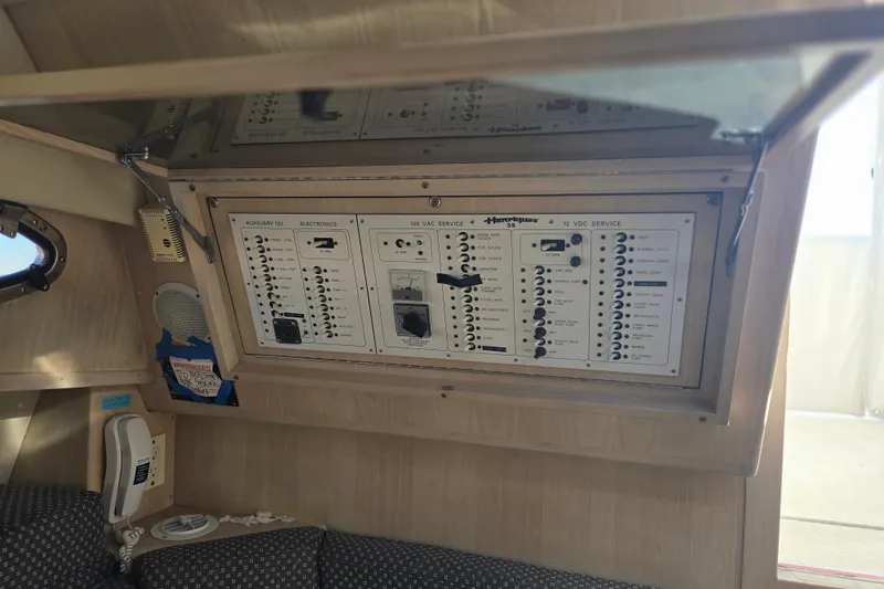 Slide: The Image of Electrical panel inside 2001 Henriques 35 Flybridge boat cabin, featuring various switches and controls. - 6