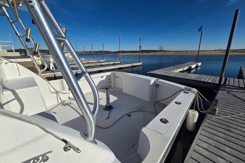 Slide: The Image of 2001 Henriques 35 Flybridge boat docked at marina under clear blue sky. - 8