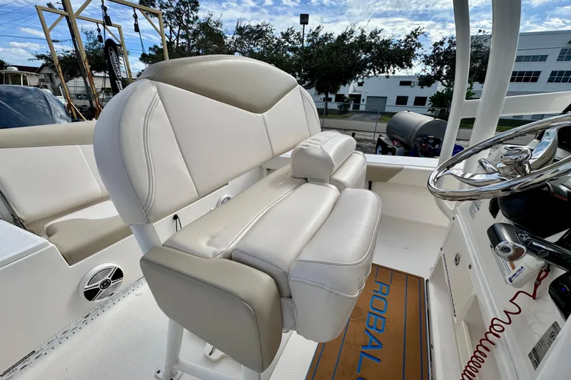 Slide: The Image of 2017 Robalo 246 Cayman boat interior with white seating and steering wheel. - 14