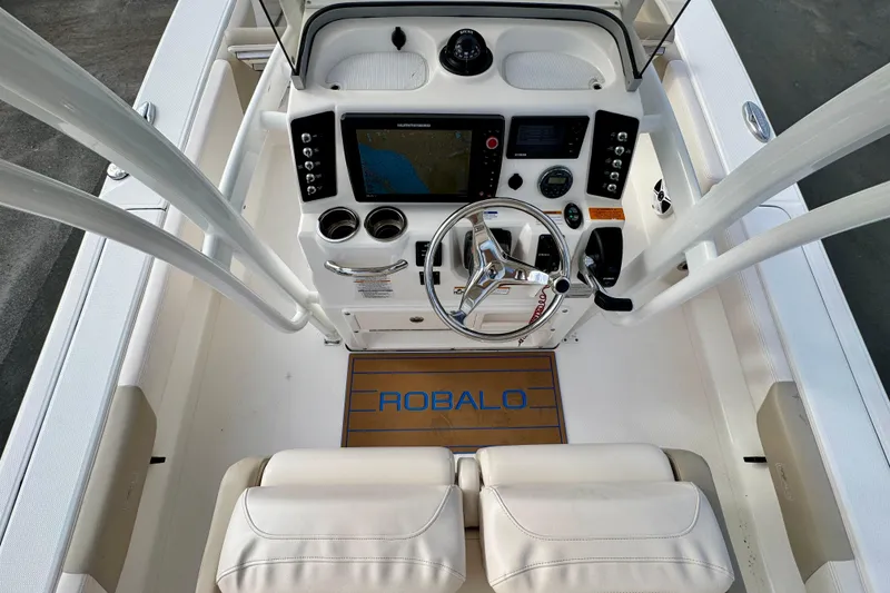 Slide: The Image of 2017 Robalo 246 Cayman boat cockpit with steering wheel and navigation controls. - 16
