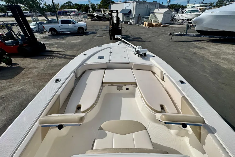 Slide: The Image of 2017 Robalo 246 Cayman boat interior with seating and storage, parked in a marina. - 19