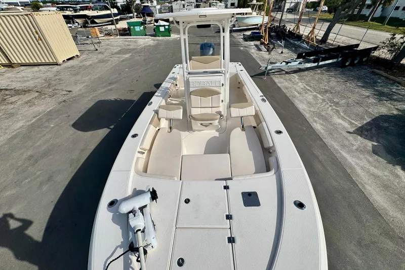 Slide: The Image of 2017 Robalo 246 Cayman boat, white interior, parked on a lot with storage containers. - 22
