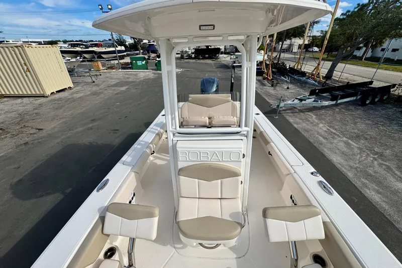 Slide: The Image of 2017 Robalo 246 Cayman boat with seating, docked outdoors under clear skies. - 23