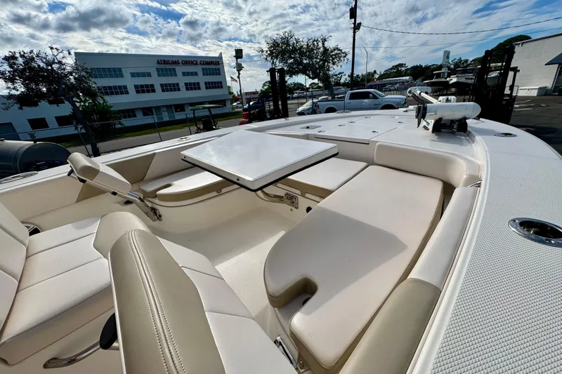 Slide: The Image of 2017 Robalo 246 Cayman boat interior with seating and table, parked near office complex. - 26
