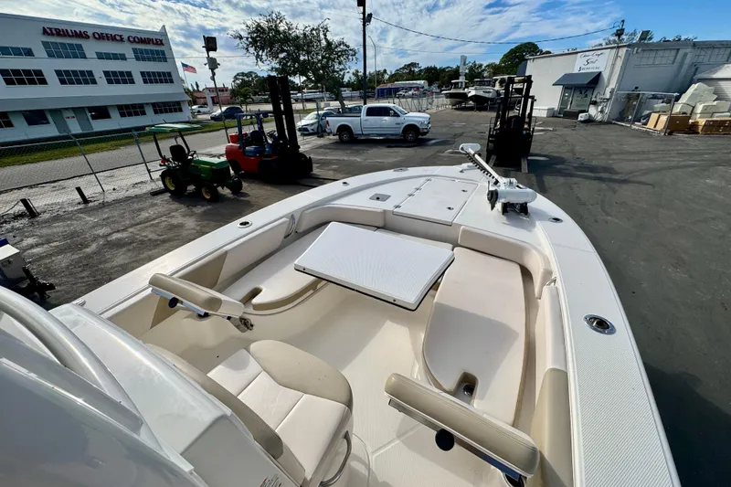 Slide: The Image of 2017 Robalo 246 Cayman boat with seating and table, parked near office complex. - 27