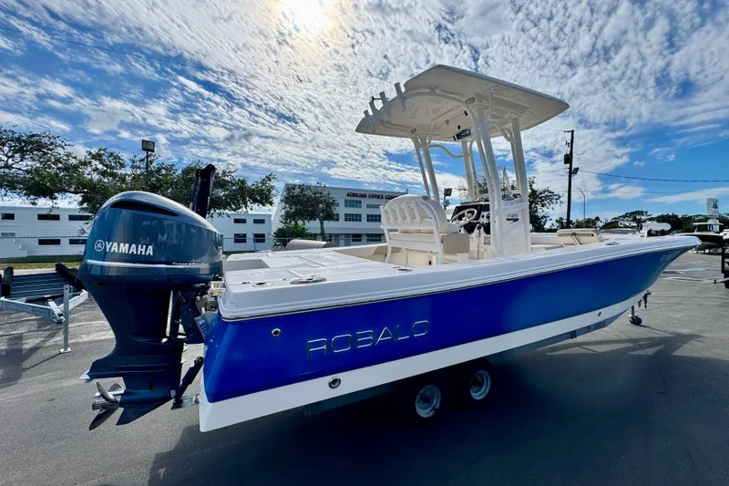Slide: The Image of 2017 Robalo 246 Cayman boat with Yamaha engine, parked outdoors under a cloudy sky. - 4