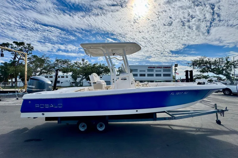 Slide: The Image of 2017 Robalo 246 Cayman boat on trailer under a partly cloudy sky. - 5