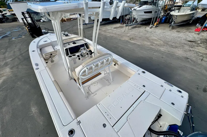 Slide: The Image of 2017 Robalo 246 Cayman boat with center console and seating, docked at a marina. - 8