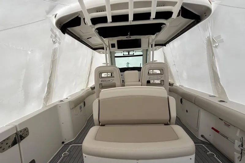 Slide: The Image of 2018 Boston Whaler 330 Outrage interior with beige seating and protective covering. - 11