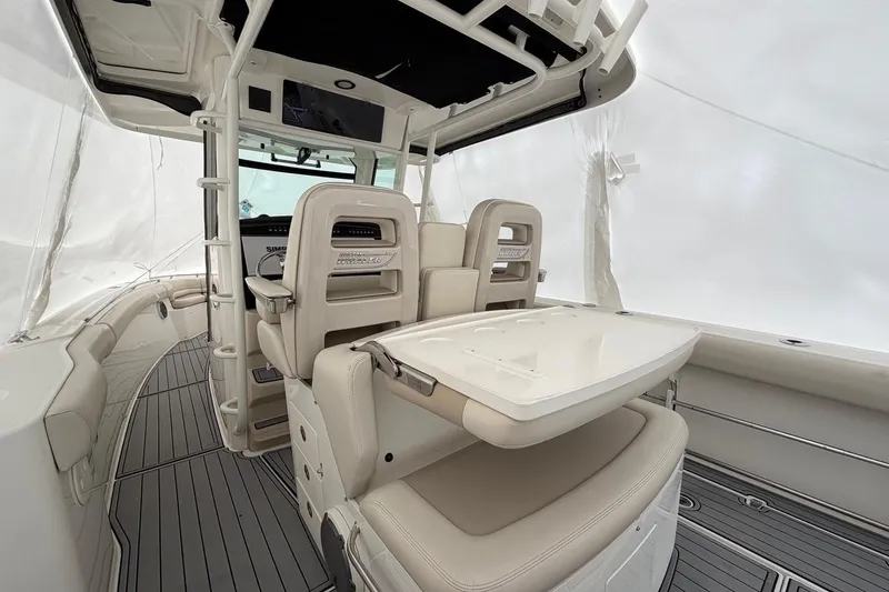 Slide: The Image of 2018 Boston Whaler 330 Outrage interior with seating and table, showcasing luxury design. - 12